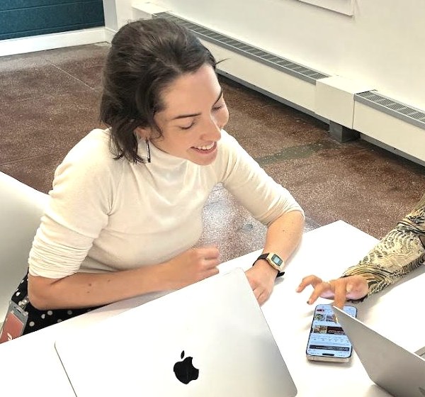 Juliette leading a research session, reviewing an app on a phone with a participant